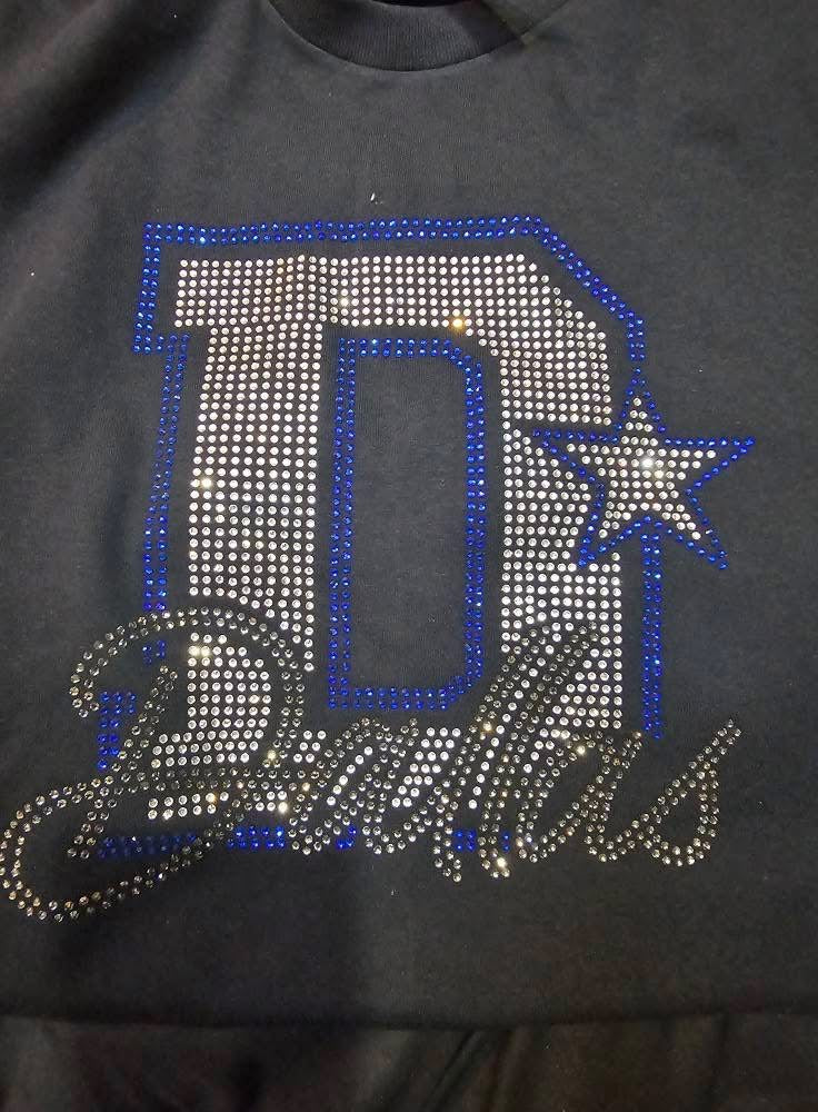Black shirt with 'D' and star design made of rhinestones on a dark background