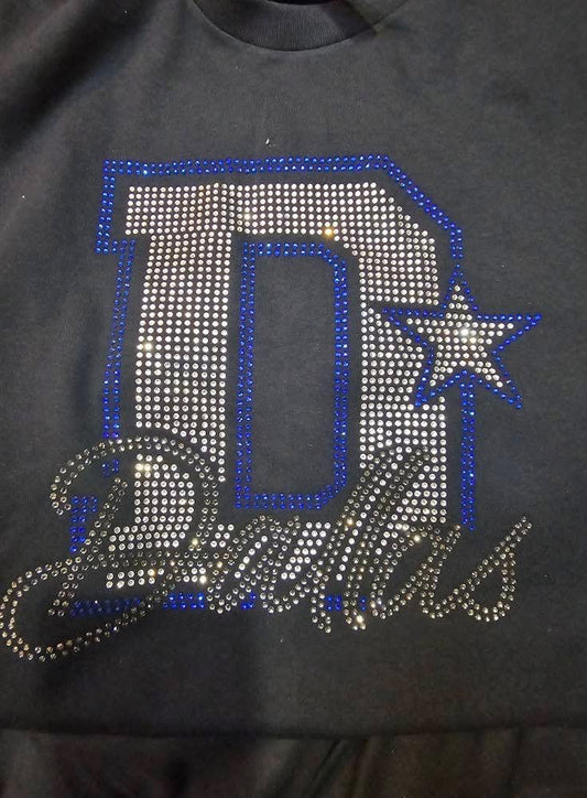 Black shirt with 'D' and star design made of rhinestones on a dark background