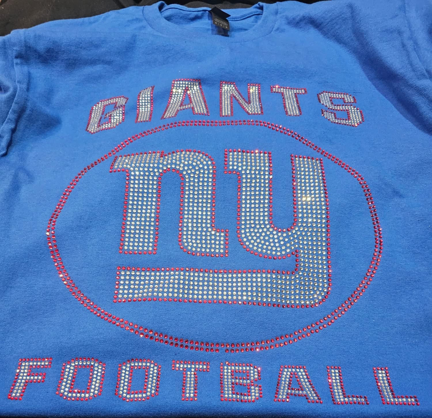 Blue t-shirt with 'GIANTS' and 'ny' text, featuring rhinestone embellishments.